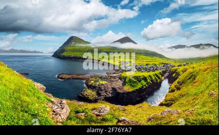 Vista pittoresca sul villaggio di Gjogv con case tipicamente colorate sull'isola Eysturoy, Isole Faroe, Danimarca. Fotografia di paesaggio Foto Stock