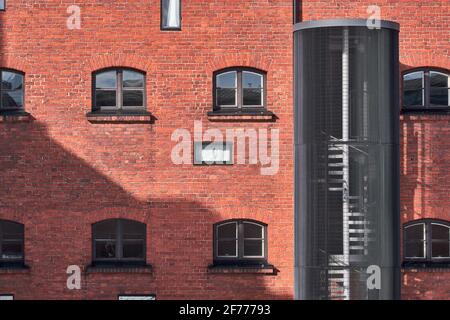 La classica architettura europea del 19 ° secolo, l'edificio in mattoni rossi della prigione, Helsinki, Finlandia. Le moderne scale esterne. Foto Stock