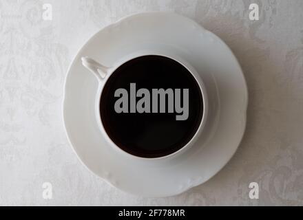 Caffè in tazza bianca su tovaglia bianca Foto Stock