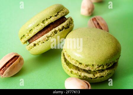 Dessert francese, pasticceria a base di meringa dolce e concetto di dolci costosi con primo piano su macaron o macaron al pistacchio verde con una b Foto Stock