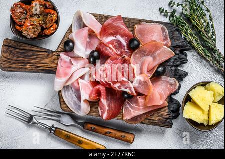 Piatto di affettati con tapas spagnole tradizionali. Sfondo bianco. Vista dall'alto Foto Stock