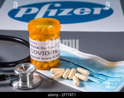 Morgantown, WV - 5 aprile 2021: Flacone e capsule da prescrizione illustra le prove Pfizer di trattamento antivirale orale per il virus SARS-COV-2 o Covid-19 Foto Stock