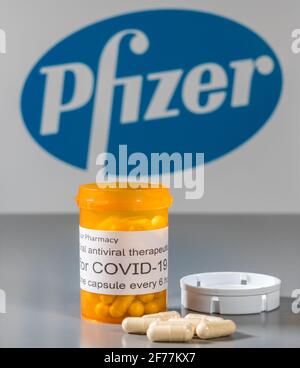 Morgantown, WV - 5 aprile 2021: Flacone e capsule da prescrizione illustra le prove Pfizer di trattamento antivirale orale per il virus SARS-COV-2 o Covid-19 Foto Stock