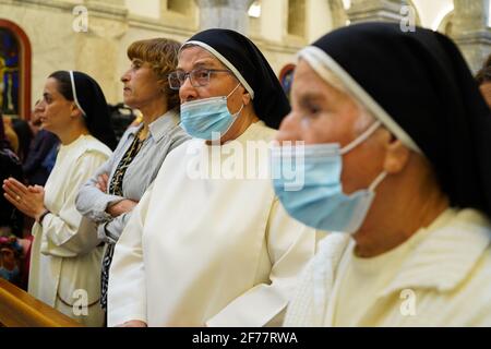 Mosul, Ninive, Iraq. 3 Apr 2021. I cristiani iracheni partecipano alla messa pasquale presso la Grande Immacolata Chiesa (al-Tahira-l-Kubra) nella città di Qaraqosh (al-Hamdaniya), a 30 chilometri a sud-est della città di Mosul. Pasqua è considerata la più grande e più grande festa cristiana, Commemora la risurrezione di Cristo dai morti dopo tre giorni della sua crocifissione e della sua morte, come scritto nel nuovo Testamento, in cui termina la Grande Quaresima che dura solitamente quaranta giorni. Durante la liturgia si cantano gli inni, si recita parte dell'Antico Testamento della Bibbia, gli inni dell'Hallelujah ar Foto Stock