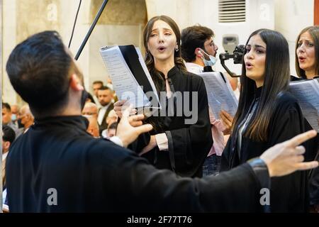 Mosul, Ninive, Iraq. 3 Apr 2021. I membri del coro della chiesa sono visti cantare durante la messa pasquale alla Chiesa Grande Immacolata (al-Tahira-l-Kubra) nella città di Qaraqosh (al-Hamdaniya), 30 chilometri a sud-est della città di Mossul. Pasqua è considerata la più grande e più grande festa cristiana, Commemora la risurrezione di Cristo dai morti dopo tre giorni della sua crocifissione e della sua morte, come scritto nel nuovo Testamento, in cui termina la Grande Quaresima che dura solitamente quaranta giorni. Durante la liturgia si cantano gli inni, si recita parte dell'Antico Testamento della Bibbia, Th Foto Stock