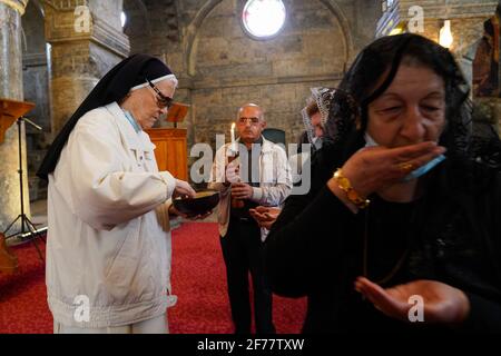 I cristiani iracheni ricevono la Santa comunione durante la messa pasquale nella Grande Chiesa Immacolata (al-Tahira-l-Kubra) nella città di Qaraqosh (al-Hamdaniya), a 30 chilometri a sud-est della città di Mosul. Pasqua è considerata la più grande e più grande festa cristiana, Commemora la risurrezione di Cristo dai morti dopo tre giorni della sua crocifissione e della sua morte, come scritto nel nuovo Testamento, in cui termina la Grande Quaresima che dura solitamente quaranta giorni. Durante la liturgia si cantano gli inni, si recita parte dell'Antico Testamento dalla Bibbia, si recita l'inno dell'Halleluia e si recita t Foto Stock