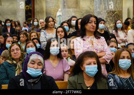 Mosul, Ninive, Iraq. 3 Apr 2021. I cristiani iracheni partecipano alla messa pasquale presso la Grande Immacolata Chiesa (al-Tahira-l-Kubra) nella città di Qaraqosh (al-Hamdaniya), a 30 chilometri a sud-est della città di Mosul. Pasqua è considerata la più grande e più grande festa cristiana, Commemora la risurrezione di Cristo dai morti dopo tre giorni della sua crocifissione e della sua morte, come scritto nel nuovo Testamento, in cui termina la Grande Quaresima che dura solitamente quaranta giorni. Durante la liturgia si cantano gli inni, si recita parte dell'Antico Testamento della Bibbia, gli inni dell'Hallelujah ar Foto Stock