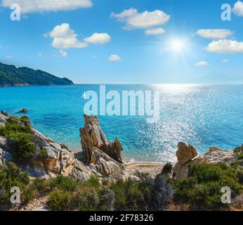 Estate sunshiny mattina piccola spiaggia sabbiosa e rocciosa costa del mare Foto Stock