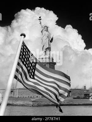 IMMAGINE COMPOSITA DEL 1940 DELLA STATUA DELLA LIBERTÀ CON UNA SPETTACOLARE NUVOLA DIETRO E 48 STELLE DI BANDIERA AMERICANA IN PRIMO PIANO - H1437 HAR001 HARS NYC PATRIOT NEW YORK CITTÀ SOVRAPPOSIZIONE PATRIOTTICA STAR AND STRIPES WORLD WAR 2 GUSTAVE EIFFEL NEW YORK CITTÀ SIMBOLICA RAME DEMOCRAZIA QUADRO FREDERIC AUGUSTE BARTHOLDI PATRIOTTISMO ROSSO STATUA BIANCA E BLU DI LIBERTY IN PRIMO PIANO IN BIANCO E NERO HAR001 ICONICO VECCHIO STILE Foto Stock