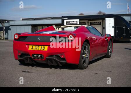 A Ferrari 458 Spider supercar in classic red parked at a track day meeting. Foto Stock