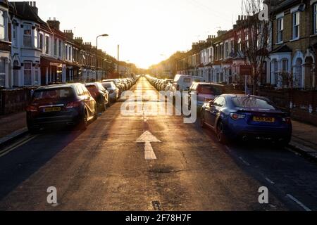 Case a schiera su entrambi i lati della strada residenziale a Londra al tramonto, Inghilterra Regno Unito Regno Unito Foto Stock