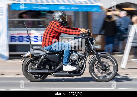 Harley Davidson motociclista, a Southend on Sea, Essex, Regno Unito. Motore S&S Super. Cavaliere che indossa una camicia in plaid e jeans in denim blu. Giorno di sole Foto Stock