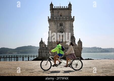 Lisbona, Portogallo. 5 Aprile 2021. La gente passa in bicicletta davanti alla Torre di Belem a Lisbona, Portogallo, 5 aprile 2021. Lunedì il presidente portoghese Marcelo Rebelo de Sousa ha chiesto "uno sforzo nazionale da parte di tutti per evitare battute d'arresto" all'inizio della seconda fase del programma di deconfinamento del paese. Credit: Pedro Feuza/Xinhua/Alamy Live News Foto Stock