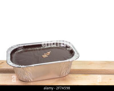 Torta al cioccolato fondente, un primo piano di mousse brownie torta fatta in casa in una tazza di lamina di alluminio isolato su sfondo bianco. Foto Stock