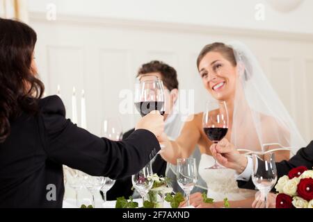 Festa di nozze a cena - la coppia nuziale è clking bicchieri con vino Foto Stock