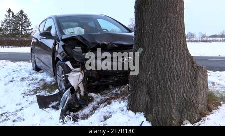 06 aprile 2021, bassa Sassonia, Schüttorf: Un veicolo si è schiantato a causa del ghiaccio nero. L'automobilista di 29 anni aveva scivolato la sua auto fuori dalla strada scivolosa e si era schiantato nell'albero al mattino. L'età di 29 anni ha subito gravi lesioni ed è stato portato in ospedale. Foto: Bernd Preikschat/NWM-TV/dpa Foto Stock