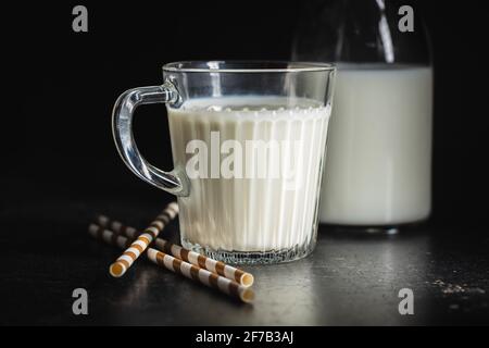 Latte bianco in tazza di vetro su tavolo nero. Foto Stock