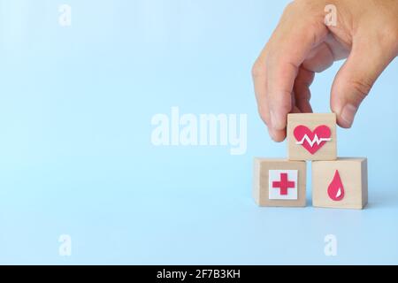 Mano scelta heartbeat heartbeat heartbeat icona su blocchi di legno con spazio di copia. Concetto di assicurazione sanitaria e di massima priorità. Foto Stock