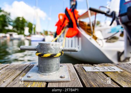 yacht ormeggiato con una linea legata intorno a un fissaggio sul molo, ormeggiare in un molo vista ravvicinata Foto Stock