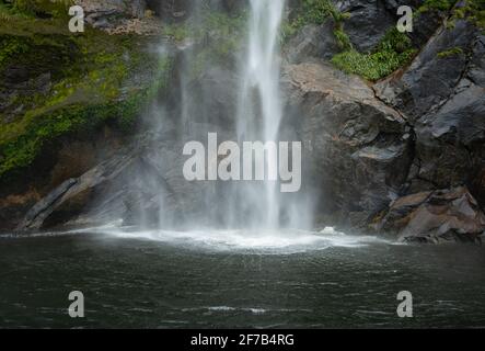 Fairy Falls che cade direttamente nel Milford Sound, con motivi radianti causati dalla forza dell'acqua a caduta libera Foto Stock