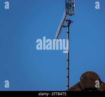 Antenna TV in alluminio alta su un tetto sotto una trasparente cielo blu Foto Stock