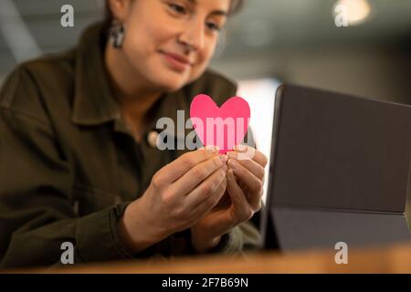 Mani della donna che tengono il cuore di carta Foto Stock
