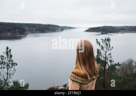 Donna che guarda al mare Foto Stock