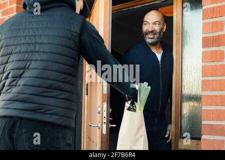 Uomo che ha lo shopping consegnato Foto Stock