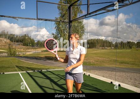 Donna che tiene racchetta di Padel Foto Stock