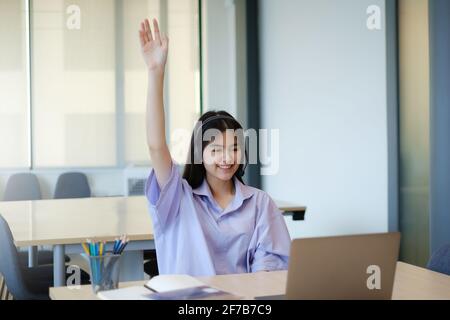 Social distancing.Stay casa. Nuovo concetto normal.Covid-19 coronavirus. I bambini sollevano la risposta di mano in su per rispondere alla domanda nella classe in linea vicino Foto Stock