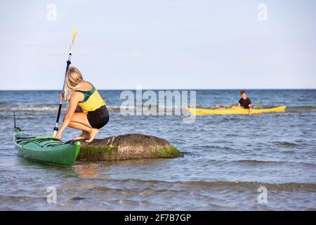 Donna kayak sul mare Foto Stock