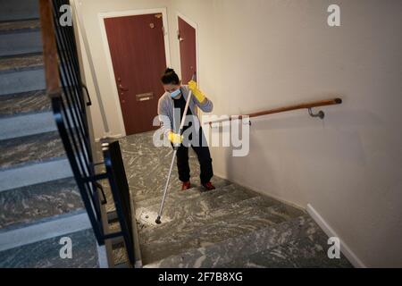 Donna mopping scala Foto Stock