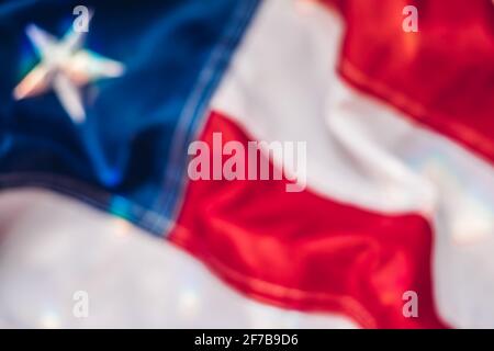 Immagine di sfondo sfocata di frammento di bandiera americana in multicolore raggi solari Foto Stock