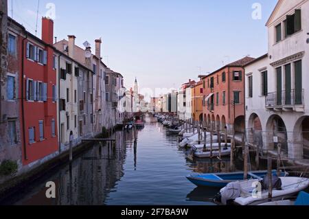 CHIOGGIA, ITALIA - 15 SETTEMBRE 2019: Il canale principale della città di Chioggia chiamato piccola Venezia con le sue barche che riflettono gli edifici adiacenti e. Foto Stock