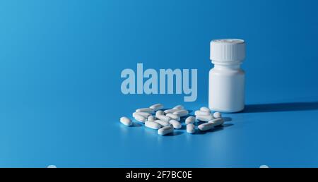 Flacone medico bianco e pillole su sfondo blu. Banner. Spazio di copia. Messa a fuoco selettiva Foto Stock