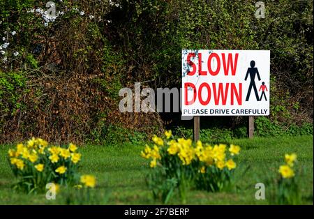 Cartello che richiede ai conducenti di rallentare attraverso il villaggio, Inghilterra Regno Unito Foto Stock