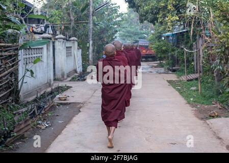 Monaci che camminano per le strade di Bago raccogliere donazioni di cibo, Bago, Myanmar Foto Stock