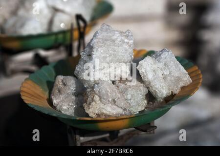 Commerciante di sale nel mercato dove il sale è tagliato in pezzi più piccoli su scala, Mopti , Mali , Africa occidentale. Foto Stock