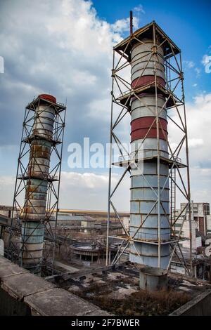 Obsoleto impianto di estrazione e trasformazione sovietico. Enormi pile di fumo. Foto Stock