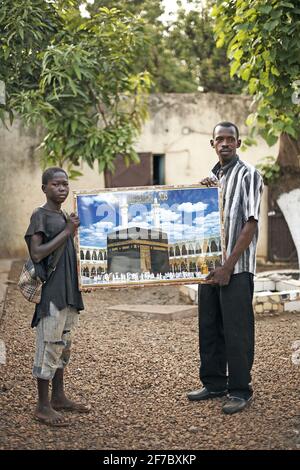 A persone che hanno un grande poster Mecca a Bamako , Mali, Africa occidentale. Foto Stock