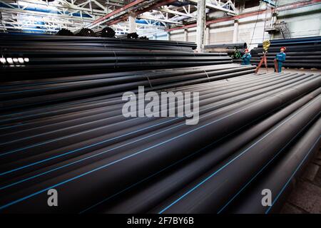 Stepnogorsk, Kazakhstan - 04 aprile 2012: Magazzino impianti di produzione tubi in plastica. Operatori con gancio per gru. Foto Stock