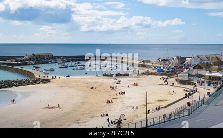 Lyme Regis, Dorset, Regno Unito. 6 aprile 2021. Regno Unito Meteo: Luminoso e soleggiato con una fresca brezza presso la località balneare di Lyme Regis. Il pittoresco resort sulla Costa Sud gode di un inizio luminoso e soleggiato mentre molte parti del Regno Unito si svegliano con una coperta di neve. La spiaggia era oggi molto più tranquilla nonostante le condizioni luminose dovute alla fresca brezza. Credit: Celia McMahon/Alamy Live News. Foto Stock