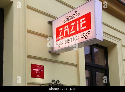 Cracovia. Cracovia. Polonia. 'Zazie Bistro' cucina francese che offre un cartello ristorante sulla facciata. Segno rosso del piatto Michelin: Buona cucina Michel Foto Stock