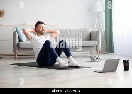 Uomo sorridente che lavora con l'abs, utilizzando un computer portatile Foto Stock
