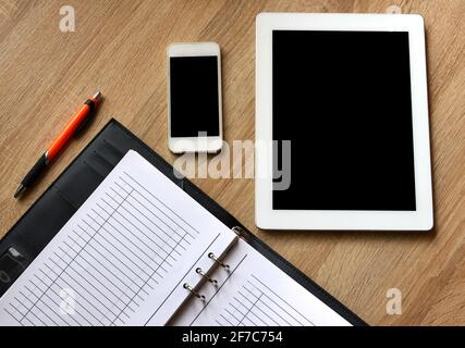 Apri libro, tablet e smartphone sulla scrivania. Sfondo dell'ufficio Foto Stock