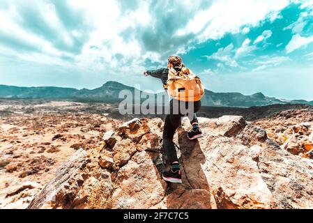 Donna con zaino trekking le montagne - escursionista di successo sulla cima della scogliera che punta il cielo - concetto di sport, persone e stile di vita Foto Stock