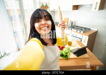 Femmina cibo blogger cucina cibo sano in cucina - donna anziana prendendo un selfie a casa durante la preparazione del pranzo - persone, cibo e vlogger concep Foto Stock