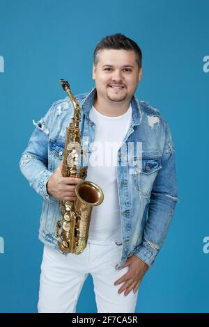 musicista uomo con il sassofono sullo sfondo dello studio. Foto Stock