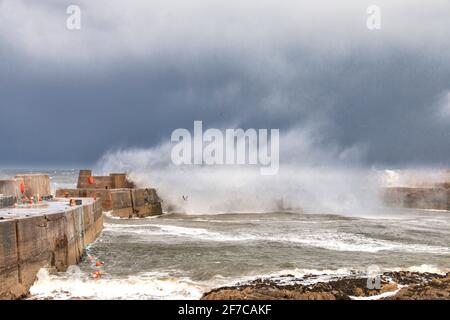 PORTKNOCKIE MORAY COSTA SCOZIA TEMPESTA GRAVE E VENTI MOLTO ALTI ROTTURA DI ONDE E SPRAY SULLE PARETI DEL PORTO Foto Stock