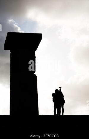 I turisti dalle silhouette scattano un selfie da una colonna dorica sull'acropoli di Lindos a Rodi, Grecia. L'Acropoli di Lindian è la principale attrazione turistica Foto Stock